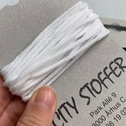 Elastik - tynd, rund og bl�d i hvid eller sort. Til fx mundbind