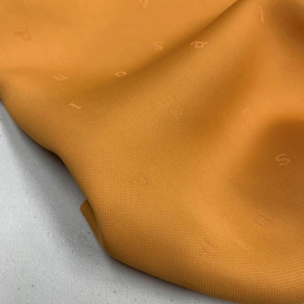 Viskose i sennepsgul med sm indvvede bogstaver - pr. 0,25 meter