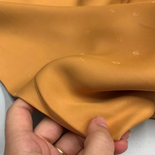 Viskose i sennepsgul med sm indvvede bogstaver - pr. 0,25 meter